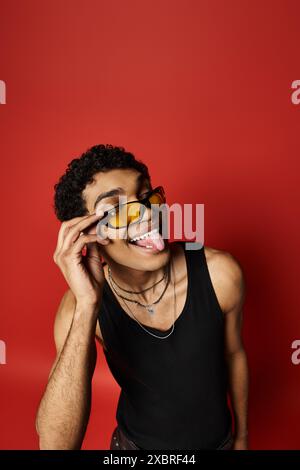 Schöner afroamerikanischer Mann mit Sonnenbrille, der verspielt seine Zunge herausstreckt. Stockfoto