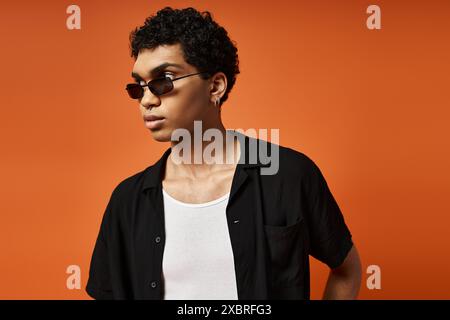 Hübscher junger Mann in schwarzem Hemd mit stylischer Sonnenbrille. Stockfoto