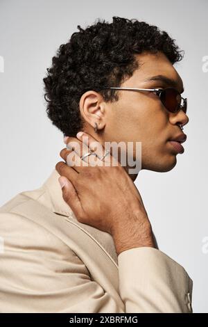 Hübscher afroamerikanischer Mann in braunem Anzug, Sonnenbrille und Ring am Finger. Stockfoto