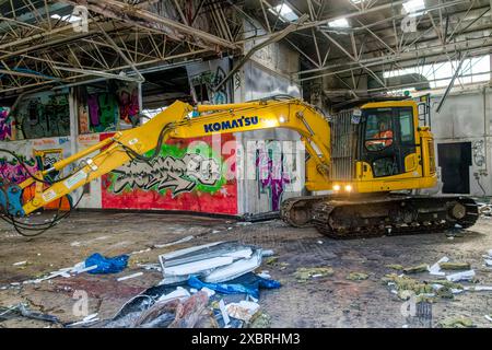 Innenansicht eines Außengebäudes mit Bulldozer in der verfallenen Torridge Vale Milk Factory mit Graffiti und Work Team während des Abbruchs; Torrington Stockfoto