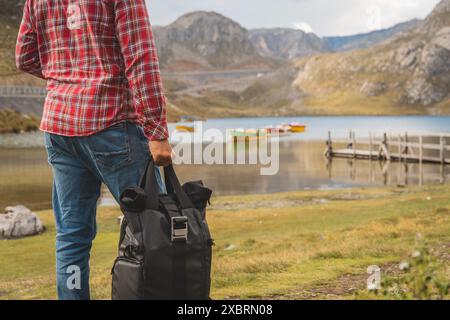 Ein Mann mit kariertem Hemd und Jeans steht auf einer Brücke mit Blick auf eine Lagune in sieben Farben, Canta. Peru. Stockfoto