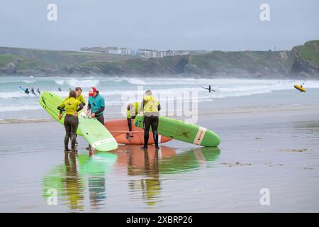 Anfänger der Escape Surf School beenden eine Lektion mit ihrem Surflehrer am Towan Beach in Newquay in Cornwall, Großbritannien. Stockfoto