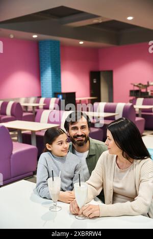 Eine glückliche Familie sitzt am Restauranttisch und genießt am Wochenende eine gemeinsame Zeit in modernem Ambiente. Stockfoto