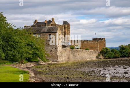 Das zerklüftete Blackness Castle hebt sich vor der dramatischen Küstenkulisse des Firth of Forth ab, der die Küstennäherungen bewacht. Stockfoto