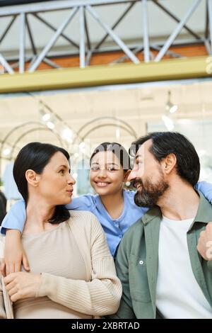 Eine glückliche Familie teilt sich einen Moment der Verbindung und schaut sich während ihres Einkaufsausflugs im Einkaufszentrum liebevoll an. Stockfoto