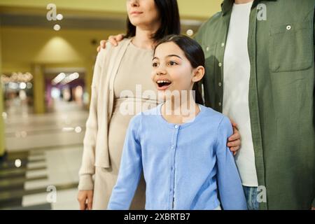 Eine glückliche Familie macht mit ihrer Tochter einen Einkaufsbummel im Einkaufszentrum. Stockfoto