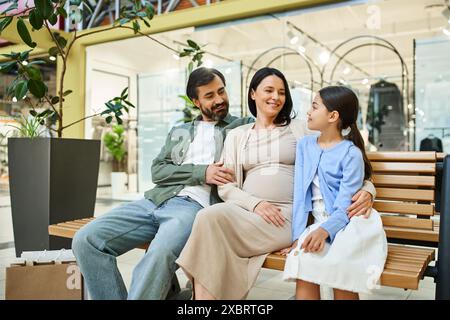 Eine fröhliche Familie genießt einen Einkaufstag, sitzt zusammen auf einer Bank in einem geschäftigen Einkaufszentrum. Stockfoto