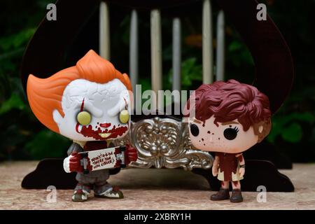 Funko Pop Actionfiguren von Pennywise Clown und Beverly Marsh aus dem Horrorfilm IT. Dunkle Fantasy, verlassener, klassischer Miniaturpavillon mit Säulen. Stockfoto