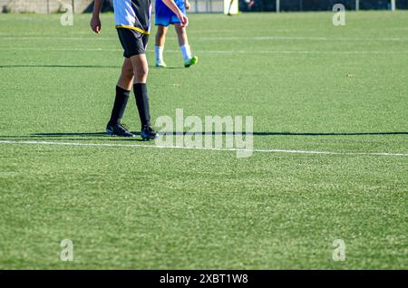 Blick auf die Beine zweier Fußballspieler auf einem Kunstrasen-Fußballplatz Stockfoto