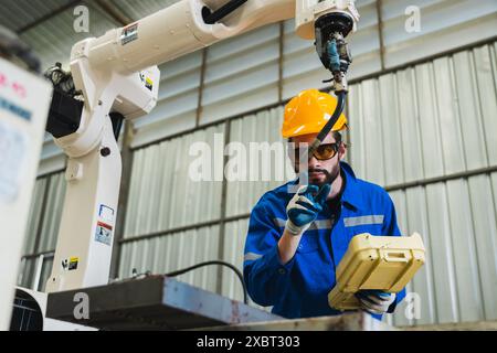 Ingenieur, der den Roboterarm im Werk steuert. Funktion des Roboterarms prüfen. Technologie, Automatisierung, Innovation und Ingenieurkonzept. Stockfoto