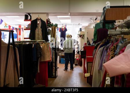 Leute unterhalten sich in einem Wohltätigkeitsladen in Newquay in Cornwall, Großbritannien. Stockfoto