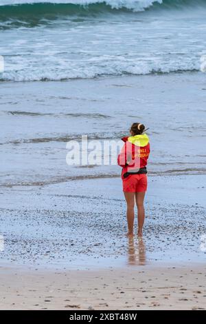 Eine RNLI-Rettungsschwimmerin im Dienst am Fistral Beach in Newquay in Cornwall in Großbritannien. Stockfoto