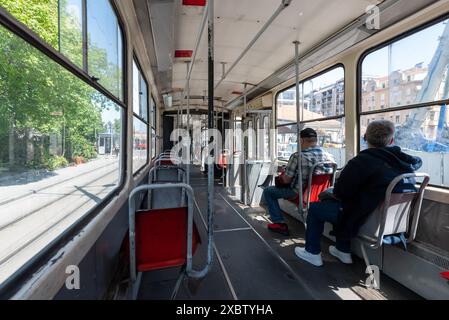 Innenraum einer lokalen Straßenbahn in Belgrad mit nur wenigen Fahrgästen. April 2024. Stockfoto