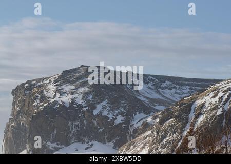 Gefrorener Wasserfall in einer schneebedeckten Berglandschaft in Island Stockfoto