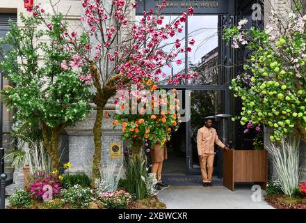 Eingang mit Blumendekoration des Luxushotels Gran Melia des Palazzo Venezia (oder Palazzo Assicurazioni Generali), Piazza Cordusio, Mailand, Italien Stockfoto