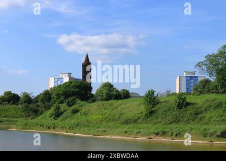 Gosport, Hampshire, England. 2. Juni 2024: Landschaft mit dem Turm der Heiligen Dreifaltigkeitskirche, Wohnblöcken und den Grasbänken der Bastion Nr. 1. Von der Haslar Road aus gesehen. Stockfoto