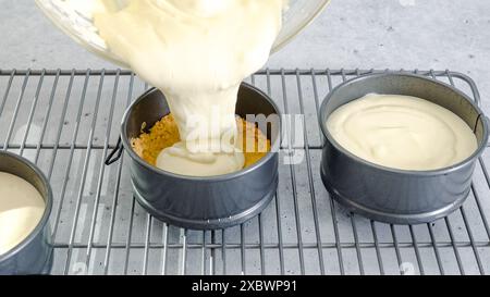 Mini-Käsekuchen Rezept. Käsekuchenteig in eine vorbereitete Backform gießen, Zubereitungsverfahren in Nahaufnahme Stockfoto