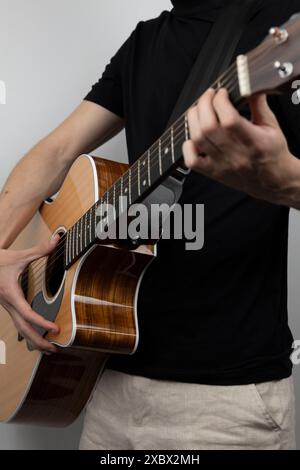 Junger Mann, der Gitarre in einem Fotostudio spielt. Stockfoto