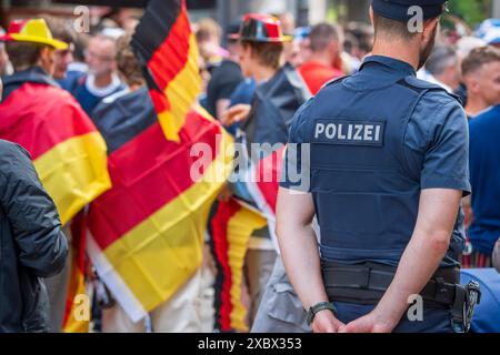 Polizist beobachtet schottische und deutsche Fußballfans in der Innenstadt, Situation friedlich, UEFA EURO 2024, München, 13. Juni 2024 Deutschland, München, 13. Juni 2024, Polizeibeamter sorgt für Sicherheit, dient als Ansprechpartner für schottische und deutsche Fußballfans, Deutschlandfahnen in der Innenstadt, Donnerstagnachmittag, Weinstraße Nähe Marienplatz, UEFA EURO 2024, ein Tag vor Beginn der Fußball-Europameisterschaft mit dem Eröffnungsspiel Deutschland gegen Schottland, Fußball, Sport, *** Polizeibeamter beobachtet schottische und deutsche Fußballfans im Stadtzentrum, Situation friedlich Stockfoto