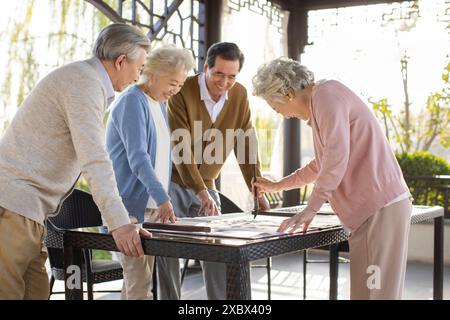 Seniorenfreunde Üben Chinesische Kalligraphie Stockfoto