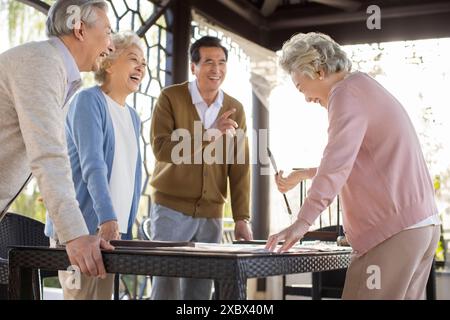 Seniorenfreunde Üben Chinesische Kalligraphie Stockfoto