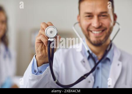 Porträt eines jungen glücklich lächelnden Arztes in medizinischer Uniform mit Stethoskop in der Klinik. Stockfoto