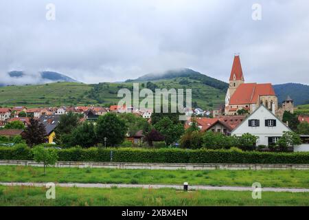 Weißenkirchen in der Wachau, Niederösterreich. Eine hübsche Stadt am Fluss mit einer traditionellen Pfarrkirche. Die Berge im Hintergrund sind eingehüllt Stockfoto