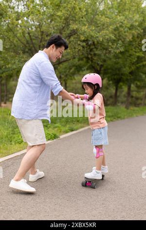 Kleines Mädchen Skateboarding Mit Dad Stockfoto