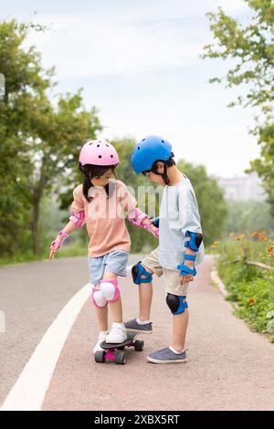 Happy Boy And Girl Skateboarding Stockfoto