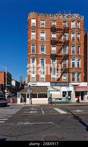 Kunstvoll verzierte Terrakotta-Spandrels und Fenster zieren dieses mittelhohe Apartment-Gebäude aus rotem Backstein in der Lower East Side von New York City. Stockfoto