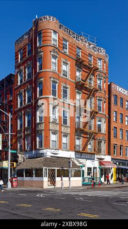 Kunstvoll verzierte Terrakotta-Spandrels und Fenster zieren dieses mittelhohe Apartment-Gebäude aus rotem Backstein in der Lower East Side von New York City. Stockfoto