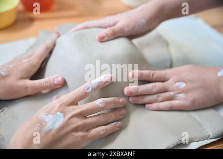 Hände unbekannter Frauen, die mit keramischen Produkten arbeiten Stockfoto