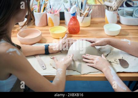 Unerkennbare Frauen in der Meisterklasse der Herstellung von Tonprodukten in der Werkstatt Stockfoto