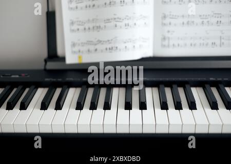 Elektronische Klaviertasten und Notenblätter in Schwarz- und Weißtönen Stockfoto