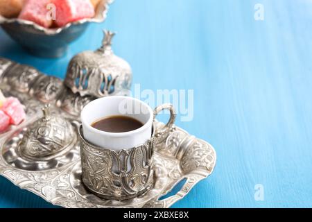 Traditioneller türkischer Kaffee und türkischer Leckerbissen auf blauem Holzhintergrund Stockfoto