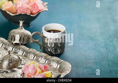 Traditioneller türkischer Kaffee und türkischer Leckerbissen auf blaugrünem Holzhintergrund Stockfoto