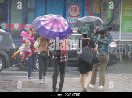 KIEW, UKRAINE - 12. JUNI 2024 - Fußgänger laufen unter Regenschirmen bei starkem Regen, der die Hälfte des Monatsdurchschnitts entsprach, Kiew, Hauptstadt der Ukraine. Stockfoto