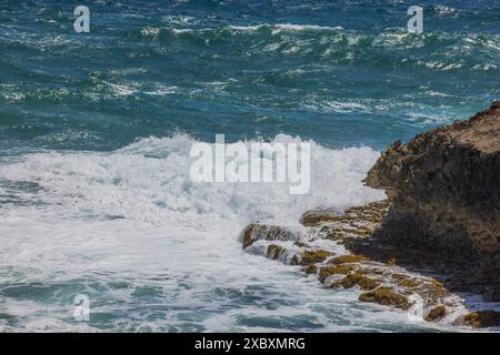 Wunderschöner Blick auf die Wellen des Karibischen Meeres, die an der felsigen Küste der Insel Aruba krachen. Stockfoto