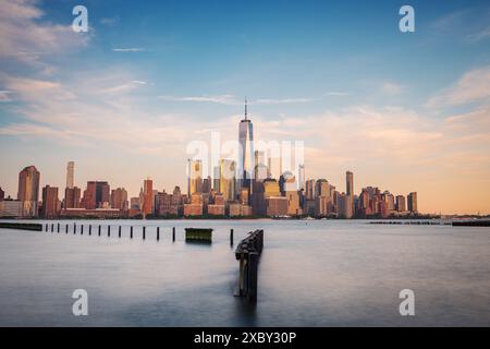 Lange Sicht der Skyline von Manhattan aus Hoboken, New Jersey, in der Abenddämmerung. Das ruhige Abendlicht unterstreicht die berühmten Wolkenkratzer der Stadt Stockfoto