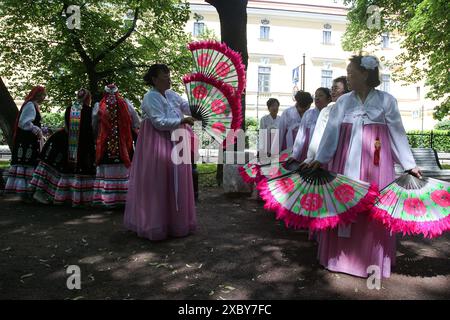 Weibliche Mitglieder einer Tanzgruppe in Nationalkostümen mit Fans, die während einer Probe einer Reihe beim „Ball der Nationalitäten“-Event zum Russland-Tag in St. Petersburg gesehen wurden. Viele zeremonielle Veranstaltungen fanden in St. Petersburg am Russland-Tag statt. Am Nachmittag fand im Alexandergarten der „Ball der Nationalitäten“ statt. Am Abend begann ein festliches Konzert auf dem Territorium der Peter-und-Paul-Festung unter Beteiligung des Gouverneurs von St. Petersburg, Alexander Beglov. Auf dem Gelände der Festung gab es verschiedene Themenspielplätze sowie Meisterkurse zum Kunsthandwerk. Außerdem Stockfoto