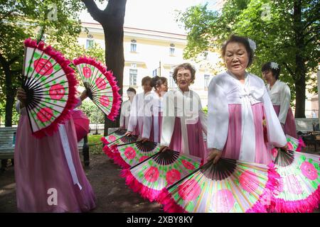 12. Juni 2024, St. Petersburg, Russland: Weibliche Mitglieder einer Tanzgruppe in Nationalkostümen mit Fans, die während einer Probe einer Reihe beim „Ball der Nationalitäten“-Event zum Russland-Tag in St. Petersburg gesehen wurden. Viele zeremonielle Veranstaltungen fanden in St. Petersburg am Russland-Tag statt. Am Nachmittag fand im Alexandergarten der 'Ball der Nationalitäten' statt. Am Abend begann ein festliches Konzert auf dem Territorium der Peter-und-Paul-Festung unter Beteiligung des Gouverneurs von St. Petersburg, Alexander Beglov. Auf dem Gelände der Festung gab es verschiedene Themenspielplätze, wie z. B. Stockfoto