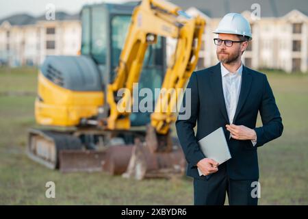 Buider-Mann in Anzug und Schutzhelm. Bauinvestor. Geschäftsmann-Investor vor der Baustelle. Erfolgreicher Investor. Ein hübscher Mann im Anzug Stockfoto