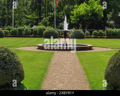 Ein gepflegter Garten mit einem sprudelnden Brunnen im Zentrum an einem Sommertag, ochtrup, münsterland, deutschland Stockfoto