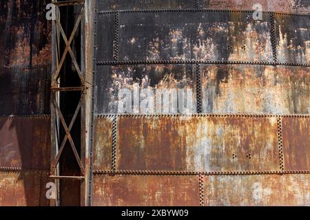 Genietete Wände eines alten Gasspeichers, bedeckt mit Rost, Industriemonument Athens Gasworks aus dem Jahr 1875, Gazi District, Athen, Griechenland Stockfoto