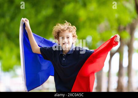 Kind mit laufender französischer Flagge. Ein Kind, das Frankreich anfeuert. Französischer Sportfan mit Nationalflagge. Happy Bastille Day. Aufgeregter Junge, der feiert Stockfoto