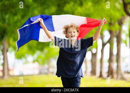 Kind mit laufender französischer Flagge. Ein Kind, das Frankreich anfeuert. Französischer Sportfan mit Nationalflagge. Happy Bastille Day. Aufgeregter Junge, der feiert Stockfoto