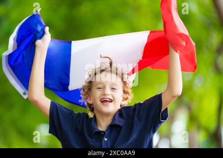 Kind mit laufender französischer Flagge. Ein Kind, das Frankreich anfeuert. Französischer Sportfan mit Nationalflagge. Happy Bastille Day. Aufgeregter Junge, der feiert Stockfoto