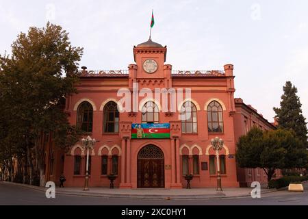 Ganja-Stadt, Aserbaidschan, 10.16.2021. Alte rote Backsteingebäude aus dem letzten Jahrhundert. Die Inschrift auf der Flagge von Karabach Aserbaidschan. Stockfoto