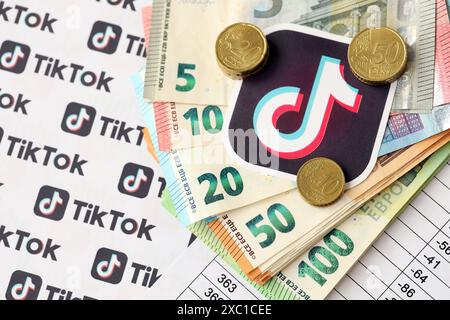 KIEW, UKRAINE - 20. APRIL 2024 TikTok-Logo und viele Euro-Geldscheine. Symbol der berühmten Plattform des sozialen Netzwerks und der europäischen Geldscheine aus nächster Nähe Stockfoto