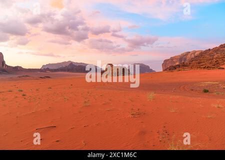Atemberaubender Sonnenuntergang überzieht den Himmel mit Pastelltönen über der Klippe Jabal Al Qattar, neben der berühmten Felsformation The Seven Pillars of Wisdom in der Stockfoto